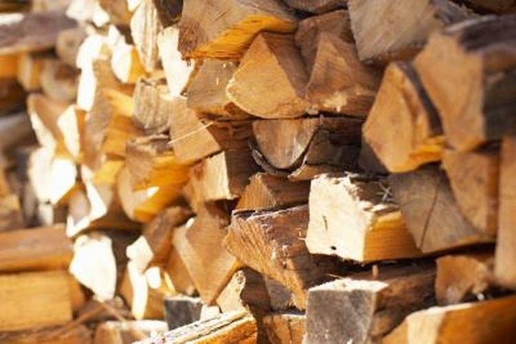 Jupiterimages/Photos.com/Getty Images Split firewood with a wedge and sledge hammer.