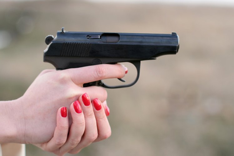 woman's hand and a gun image by Elena Vdovina from Fotolia.com A blued finish on a pistol.