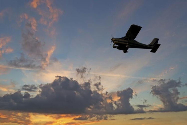 Gabriele Maltinti/iStock/Getty Images Airplane flying through the air at sunset.