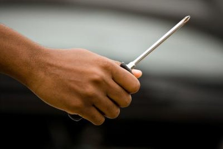 Jupiterimages/Photos.com/Getty Images Common tools such as a screwdriver are vital in adjusting the shift cable.