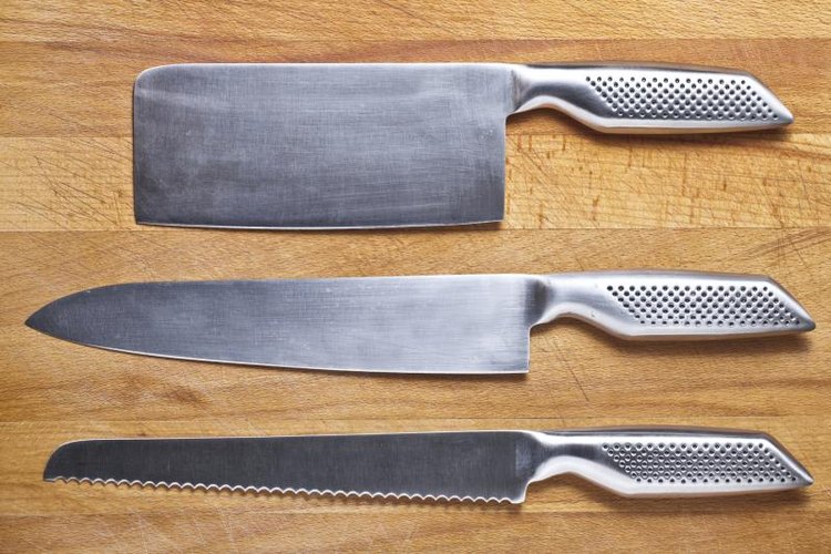 _Ra_/iStock/Getty Images Three stainless steel knives on cutting board.