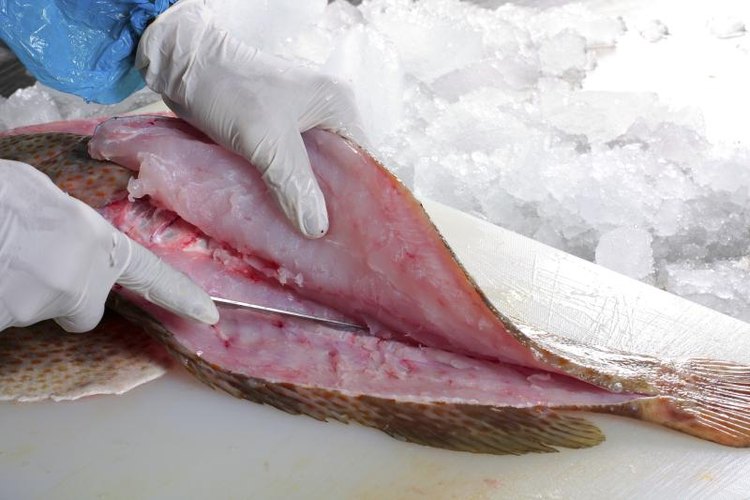 SUSANSAM/iStock/Getty Images If you don't want your hands to smell like fish, wear latex gloves.