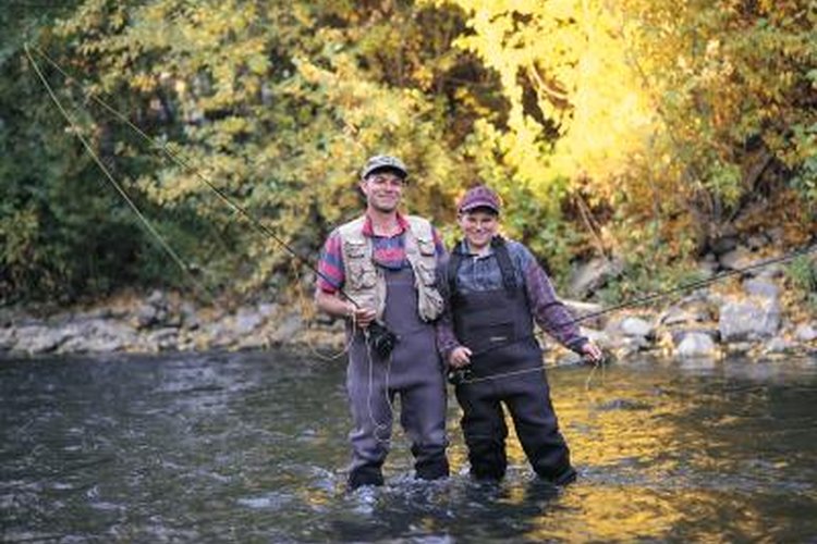 Photodisc/Photodisc/Getty Images Fly fisherman and his son wearing chest waders in a river.
