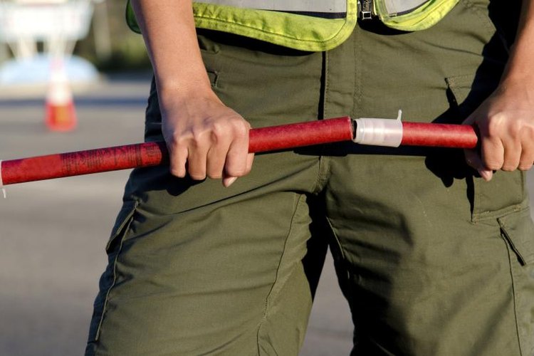 aijohn784/iStock/Getty Images Police officer about to ignite two flares.