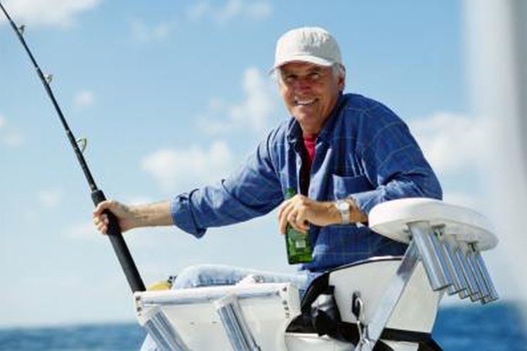 Hoby Finn/Photodisc/Getty Images Man fishing off of boat.