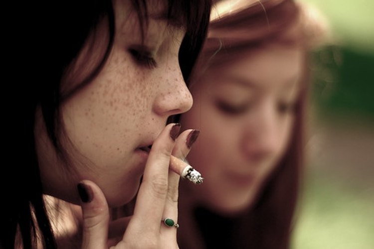 Jovencita fumando cigarrillos.