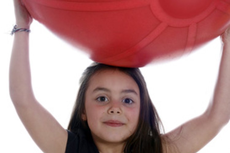 Usa una pelota medicinal para estirar tu espalda media.