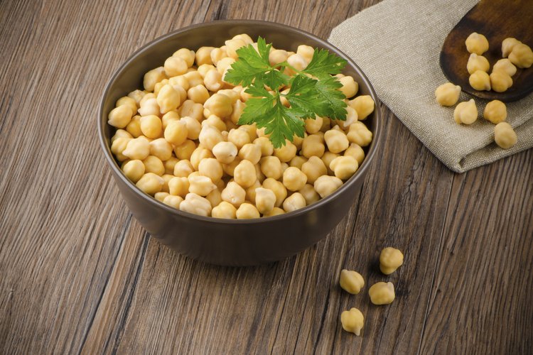Garbanzos en un recipiente sobre una mesa de madera.