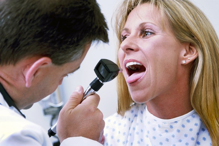 Doctor revisando la garganta de una mujer.