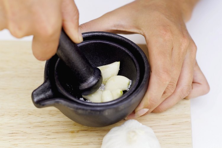 Obtén los beneficios para la salud del ajo al consumirlo completo o molerlo para saborizar los alimentos.