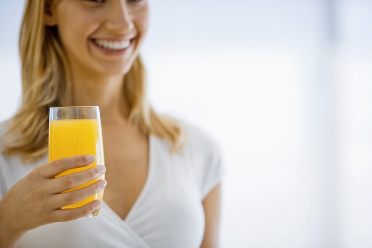 Mujer bebiendo un vaso de jugo.