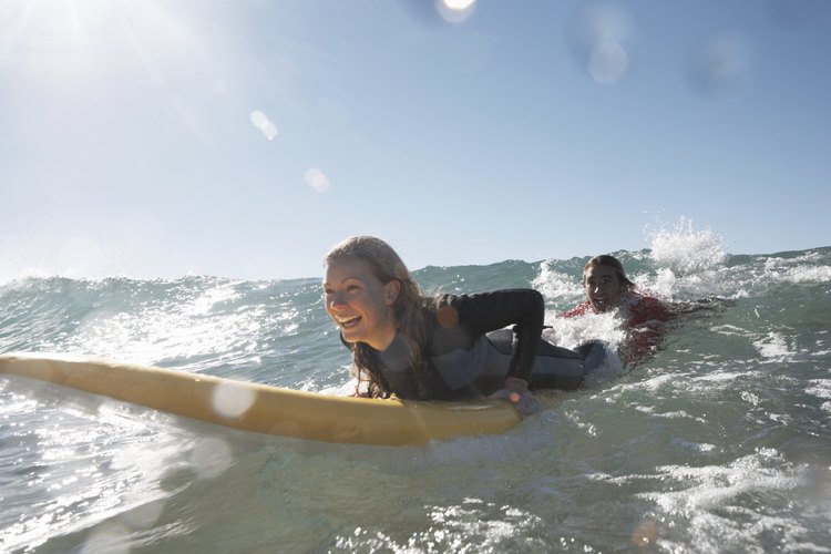 Un surfista practica levantarse en una ola.