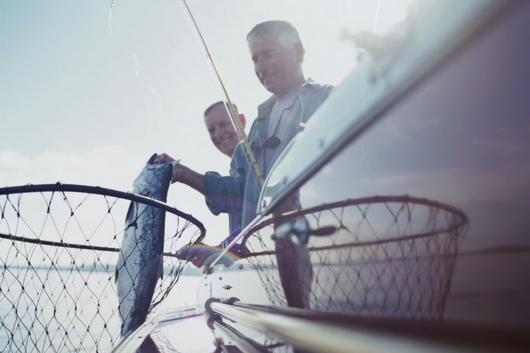 Ryan McVay/Photodisc/Getty Images Two men fishing from boat