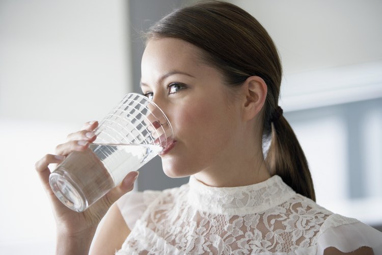 Mujer bebiendo un vaso de agua.