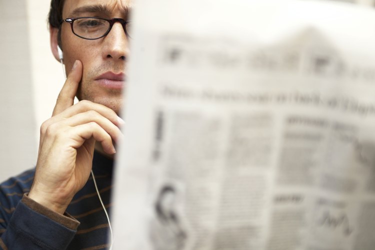 Lee un periódico.