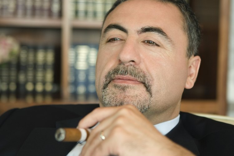 Un hombre de negocios se relaja mientras fuma un puro.