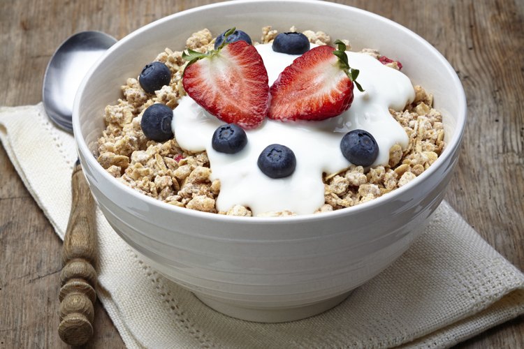 Un tazón de cereal integral con yogur y fruta.