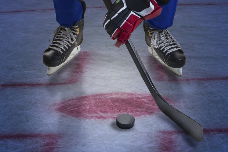 Un jugador de hockey hace un tiro para anotar un tanto.