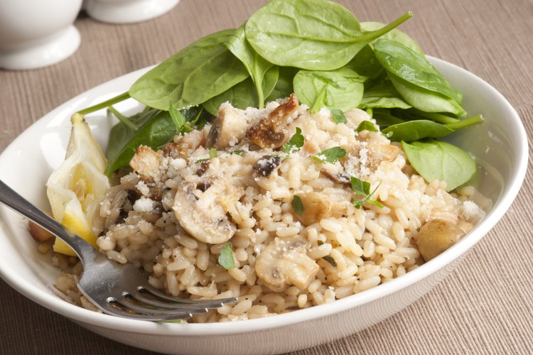 Un plato de arroz integral con una ensalada de espinacas frescas.