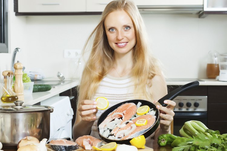 Mujer comiendo pescado.