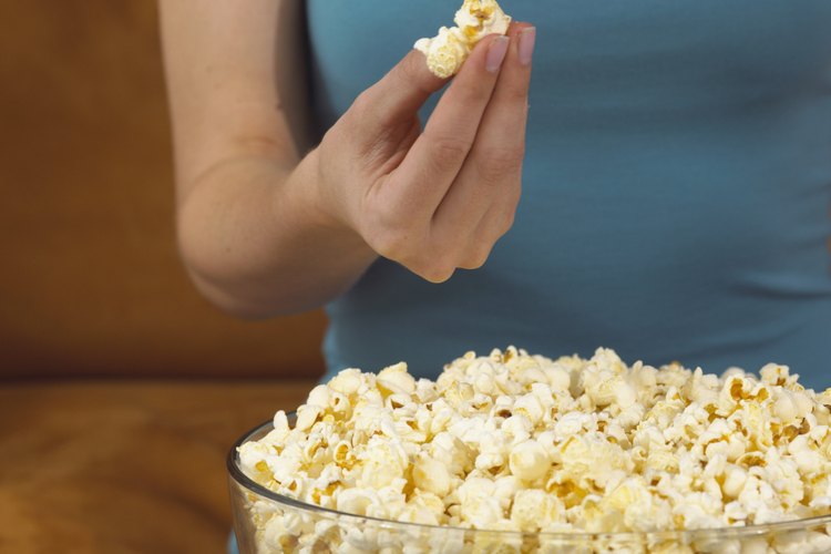 Mujer joven comiendo palomitas de maíz