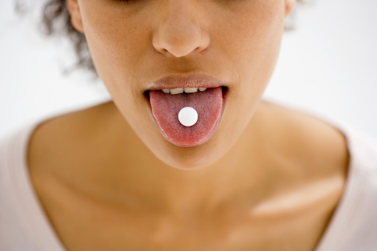 Una chica con una píldora en la lengua.