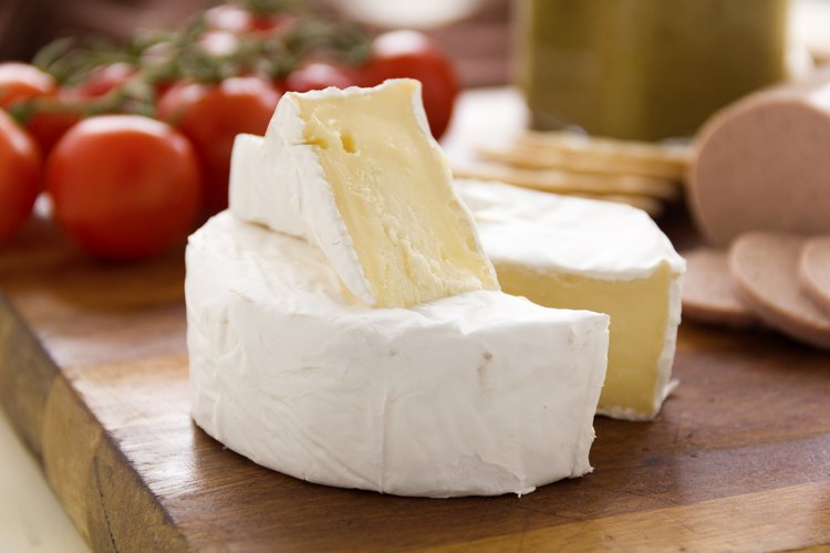 Queso camembert sobre una tabla para cortar.