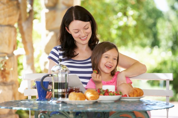 Infante comiendo fruta con su madre.