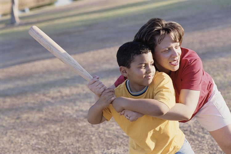 El jugador de rounders debe sostener el bate mientras corre alrededor de los postes.