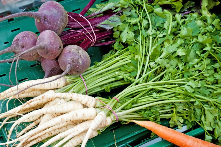 Pila de verduras de raíz sobre una mesa.