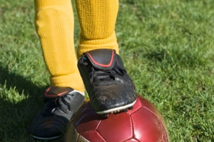 El dolor en la rodilla puede ocurrir mientras se patea un balón de fútbol.
