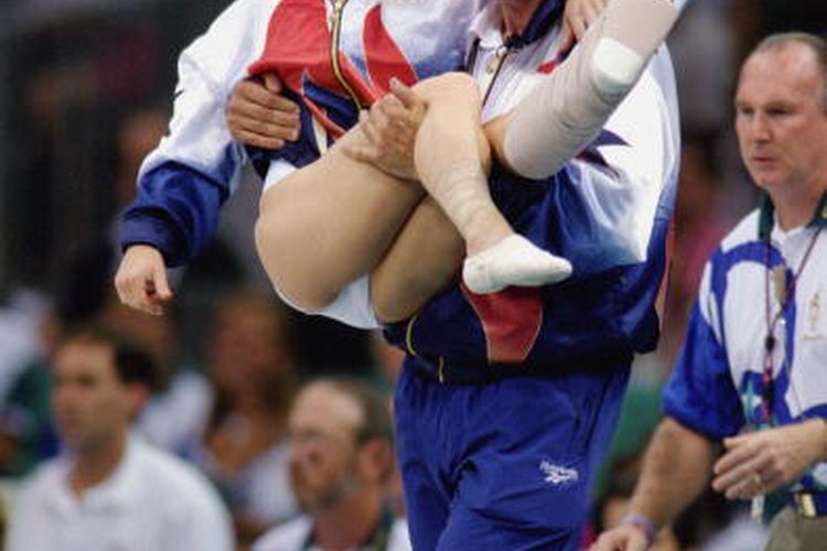 Bela Karolyi lleva a Kerri Strug, lesionada durante las Olimpíadas de 1996.
