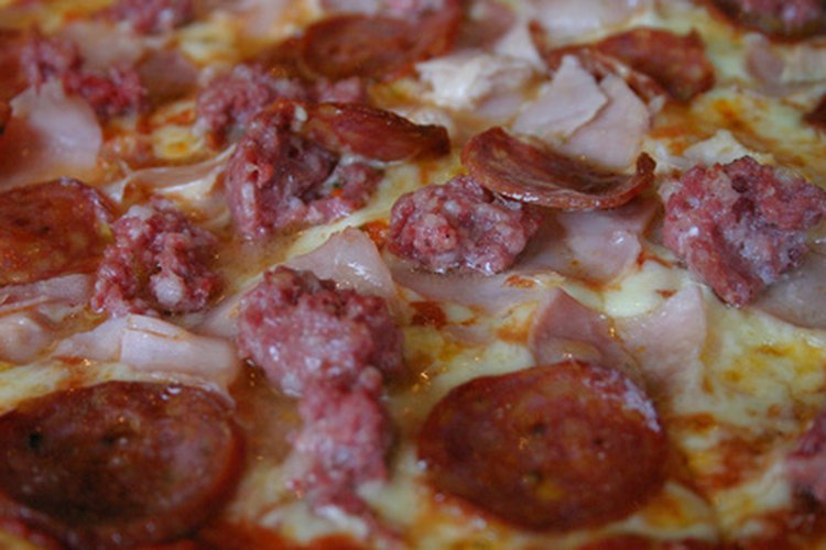 Las carnes sabrosas hacen la pizza.