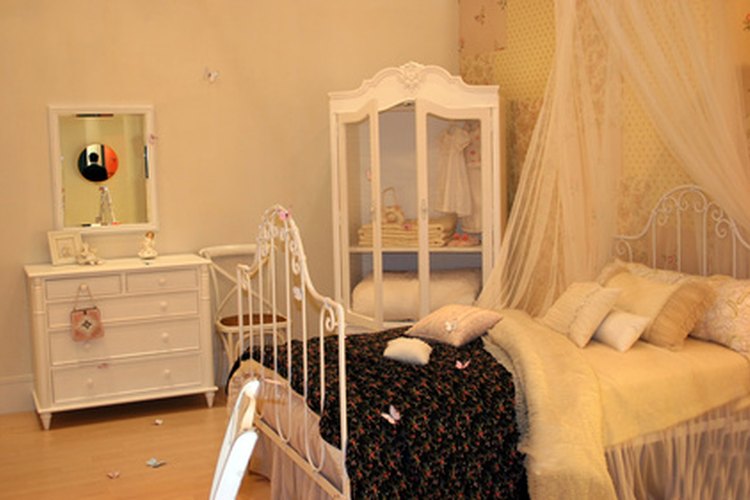 Una cama de hierro pintada complementa la decoración de una habitación.
