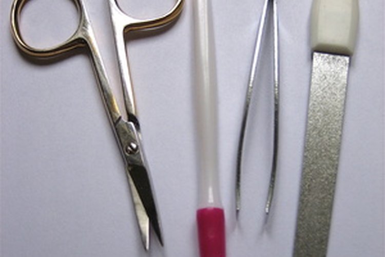 Levanta la uña postiza usando una herramienta para empujar las cutículas o una lima metálica para uñas.