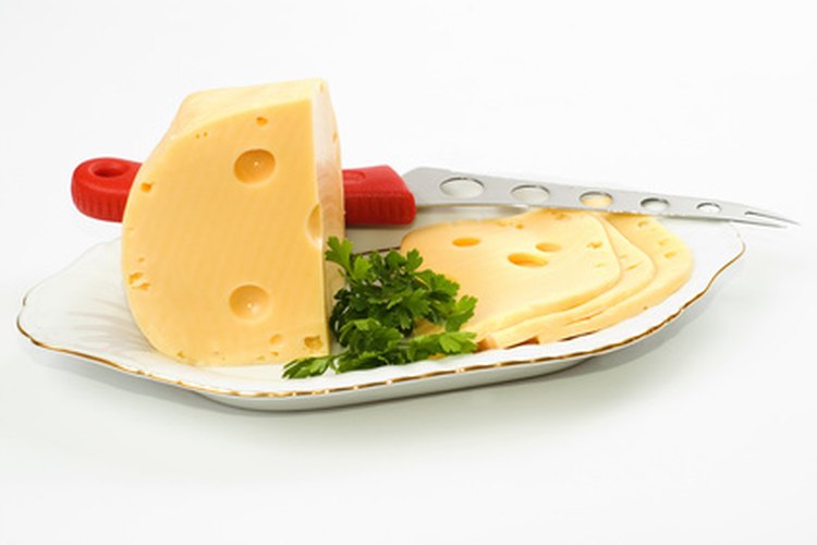 El queso suizo tiene una apariencia lisa y es de color amarillo pálido.