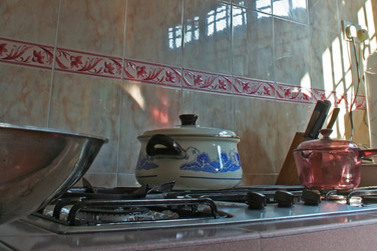 Una cocina a gas tiene perillas para controlar la temperatura a lo largo de su parte delantera.