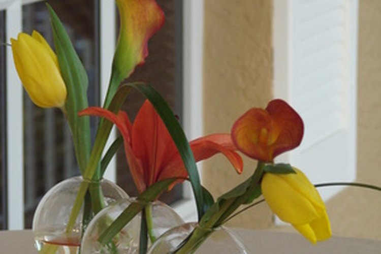 Crea un centro de mesa para fiesta deslumbrante usando jarrones con flores frescas.