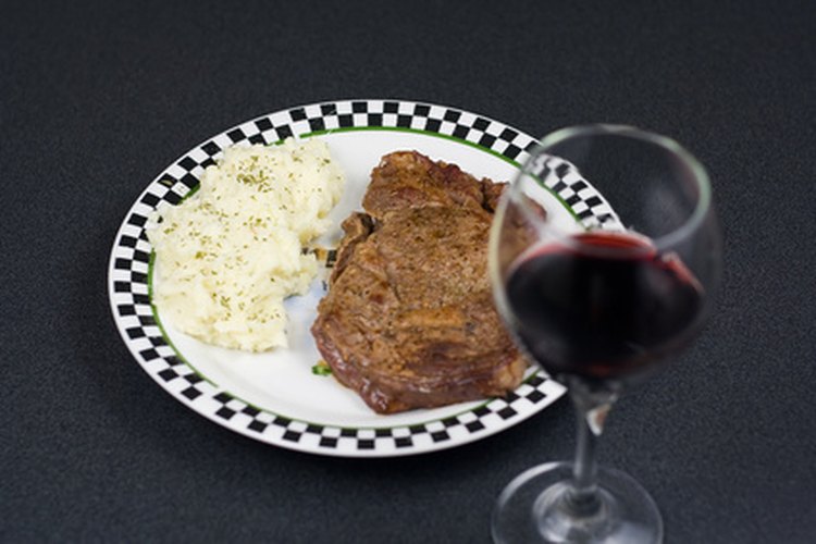 Un bistec con un vaso de vino.