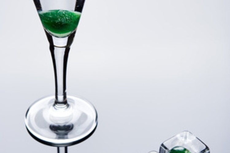 Anuncio de alcohol usando cubos de hielo, cerezas verdes, formas de cristal y reflexiones para asociar el producto con los órganos sexuales.