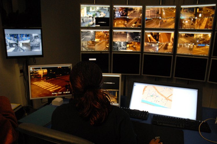 Algunos guardias de seguridad cuidan la seguridad del edificio mediante monitores de video.