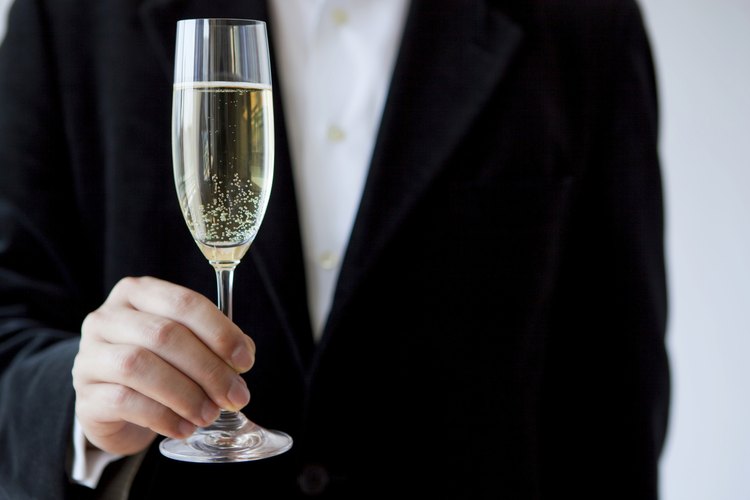 Un hombre sosteniendo una copa de champán en un evento formal.