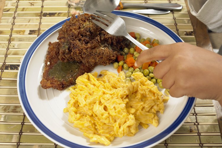 Sirve pollo frito con macarrones con queso como guarnición.