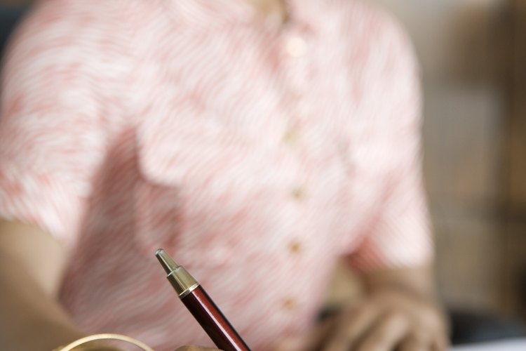 Mujer firmando un documento.