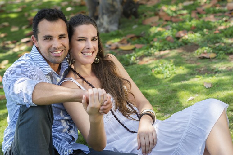 Unos novios se toman de la mano en el parque.