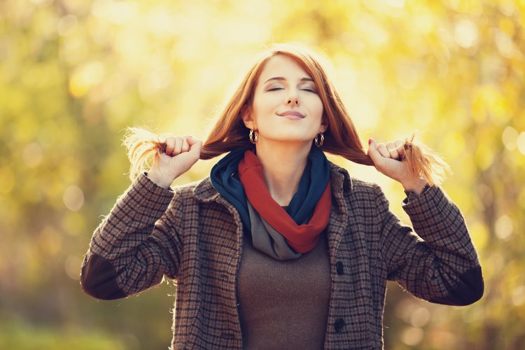 Una mujer de cabello colorado sonriendo al aire libre.