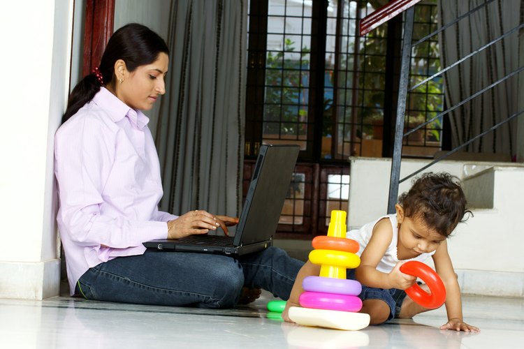 Mujer trabaja en la computadora portátil junto a un niño.
