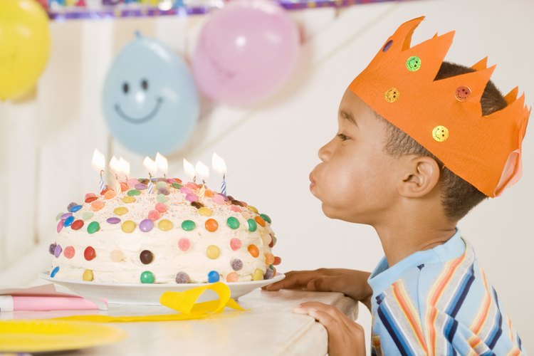 Un niño soplando velas de cumpleaños.