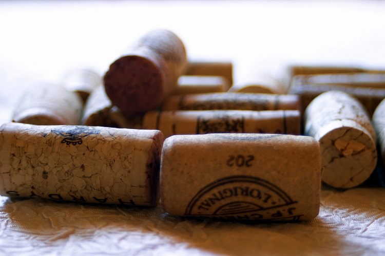 Corta corchos viejos de vino por la mitad para reciclarlos y hacer una alfombra para el baño.