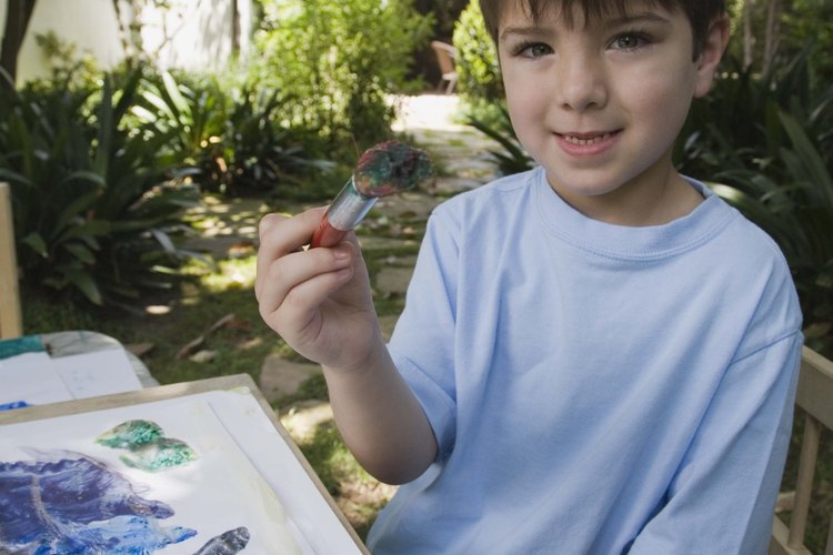 Recoger una brocha de pintura es una señal de que tu hijo está desarrolando la coordinación de manos y vista.